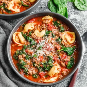 Sausage tortellini soup with spinach in a bowl.