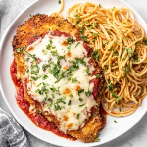 A delicious serving of Baked Chicken Parmesan, showcasing golden-brown breading and melted mozzarella cheese.