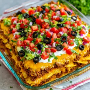 Walking Taco Casserole featured image showcases a delicious layered casserole dish with ground beef, chips, lettuce, and tomato.