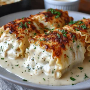 A delicious close-up showcases Chicken Alfredo Lasagna Rolls, oozing with creamy sauce and cheese.