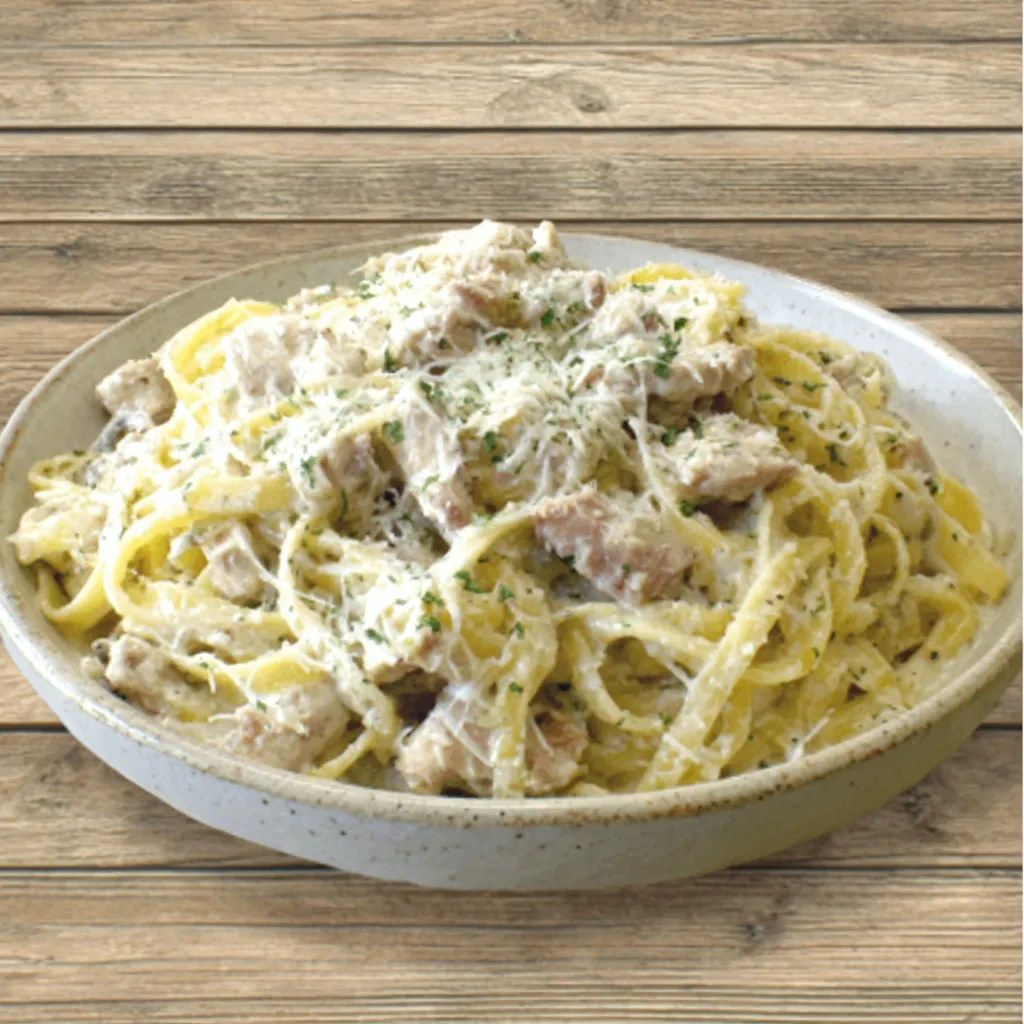 Close-up shot of a delicious plate of Creamy Chicken Alfredo, showcasing its rich sauce and tender chicken.