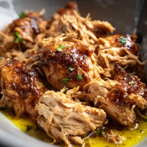 CROCKPOT MISSISSIPPI CHICKEN THE REAL DEAL 5 A bowl of savory, shredded Crockpot Mississippi Chicken topped with sliced pepperoncini peppers.