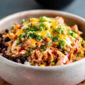 A vibrant Chicken Burrito Bowl with grilled chicken, black beans, corn salsa, rice, and fresh cilantro.