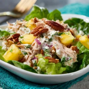 TROPICAL PINEAPPLE CHICKEN SALAD WITH PECANS 5 A fresh bowl of creamy Pineapple Chicken Salad with Pecans, garnished with fresh herbs and served on a platter.